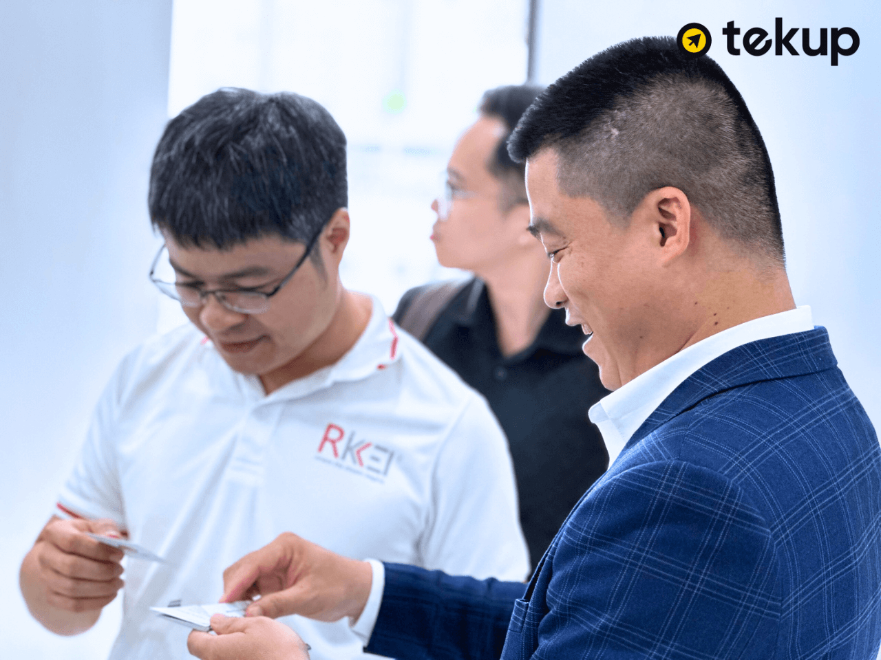 Mr. Trần Minh Lân engages in information exchange with a representative from Rikkeisoft.